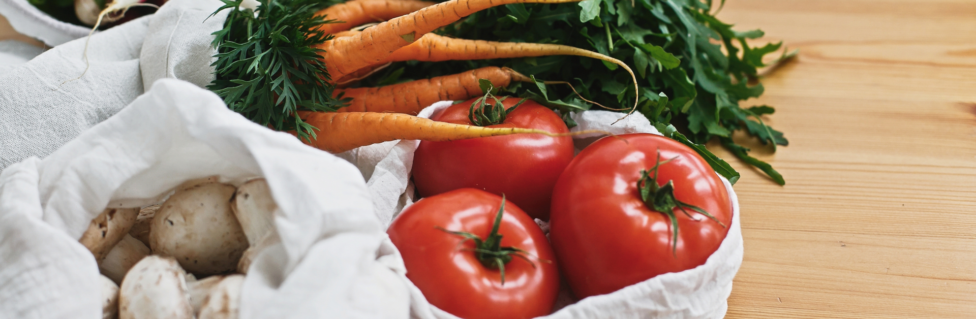 white cloth bag full of tomatoes and carrots